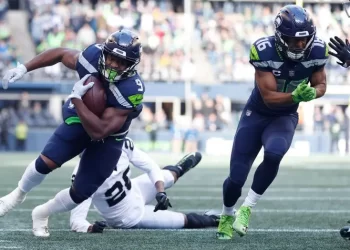 Corredor de Seattle Seahawks avanza con el balón ante defensores de Las Vegas Raiders en la pretemporada NFL 2025.