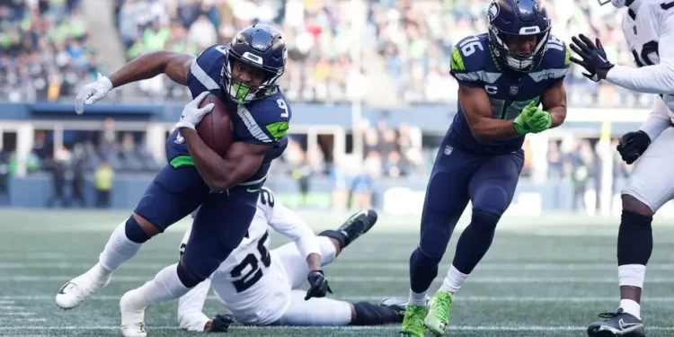 Corredor de Seattle Seahawks avanza con el balón ante defensores de Las Vegas Raiders en la pretemporada NFL 2025.