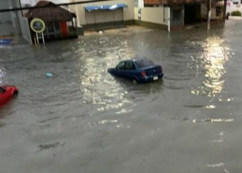 Calle inundada en Cancún con vehículos atrapados durante tormenta