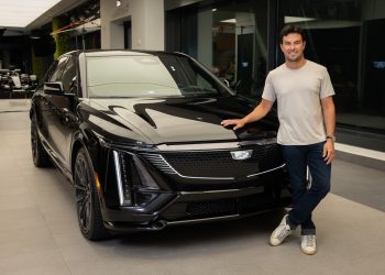 Checo Pérez posa junto a un vehículo Cadillac tras su primer día de trabajo en la F1.