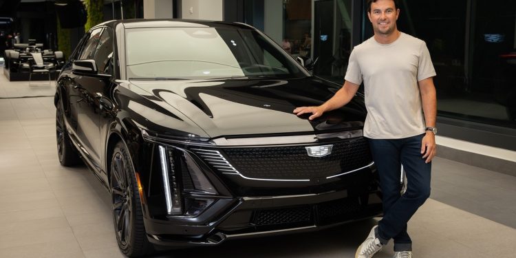 Checo Pérez posa junto a un vehículo Cadillac tras su primer día de trabajo en la F1.