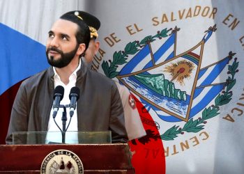 Presidente de El Salvador dando discurso con la bandera nacional de fondo.