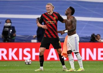 Erling Haaland y Vinicius Jr sonríen juntos en el campo, representando los rumores sobre un posible intercambio entre Real Madrid y Manchester City.