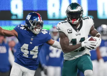 Defensivo de Giants intenta detener a receptor de Eagles en duelo divisional.