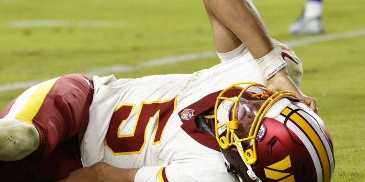Jayden Daniels sale del campo tras sufrir una lesión en el hombro durante un partido de los Washington Commanders en la NFL 2025.