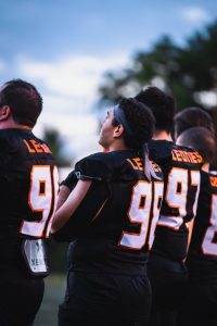 Jugadores del equipo Leones alineados antes del partido de futbol americano